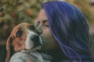 girl with purple hair holding dog